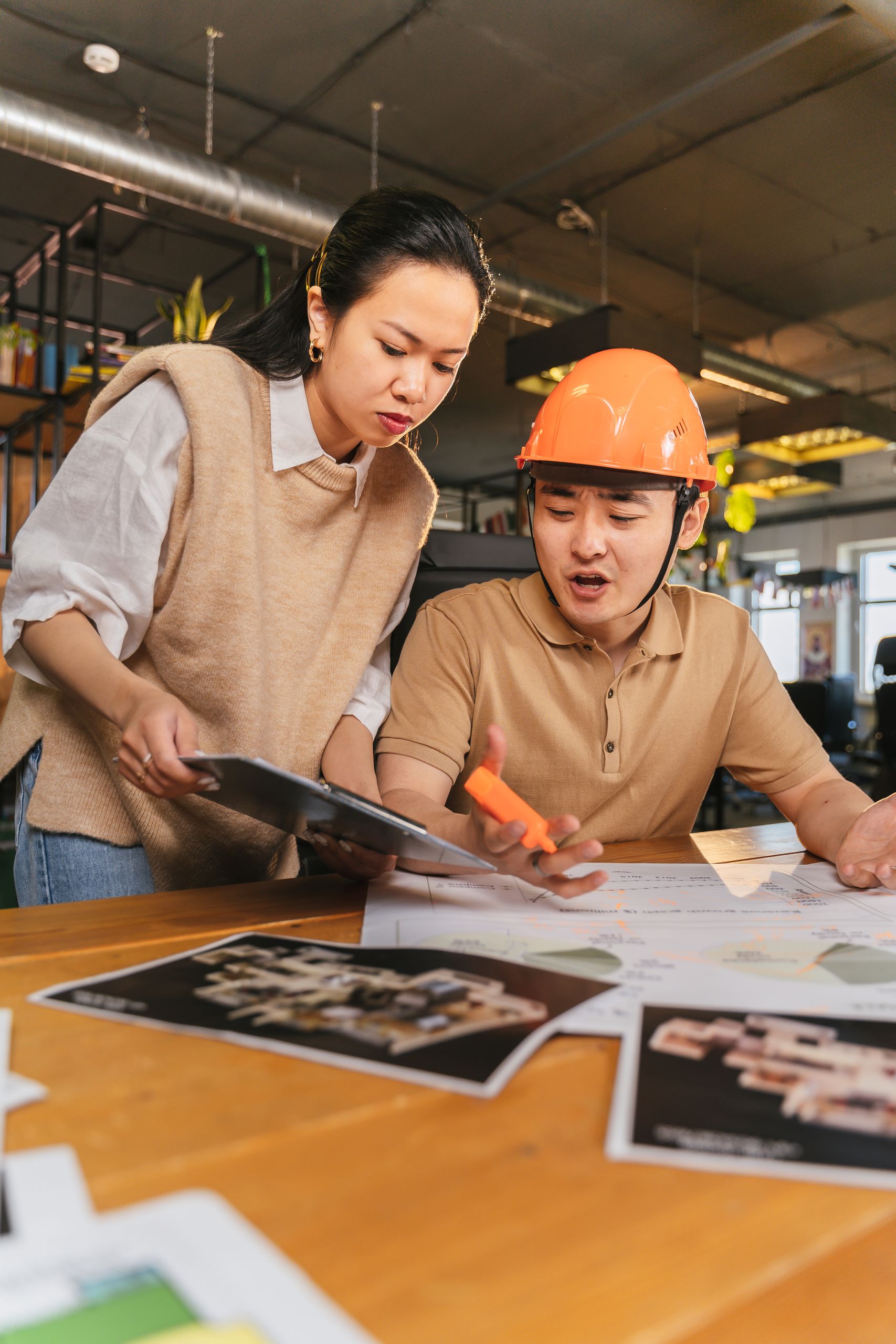 Asian coworkers collaborate on project plans, fostering teamwork and productivity.